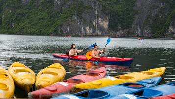 A calm lake with several kayaks and canoes docked along the shore.