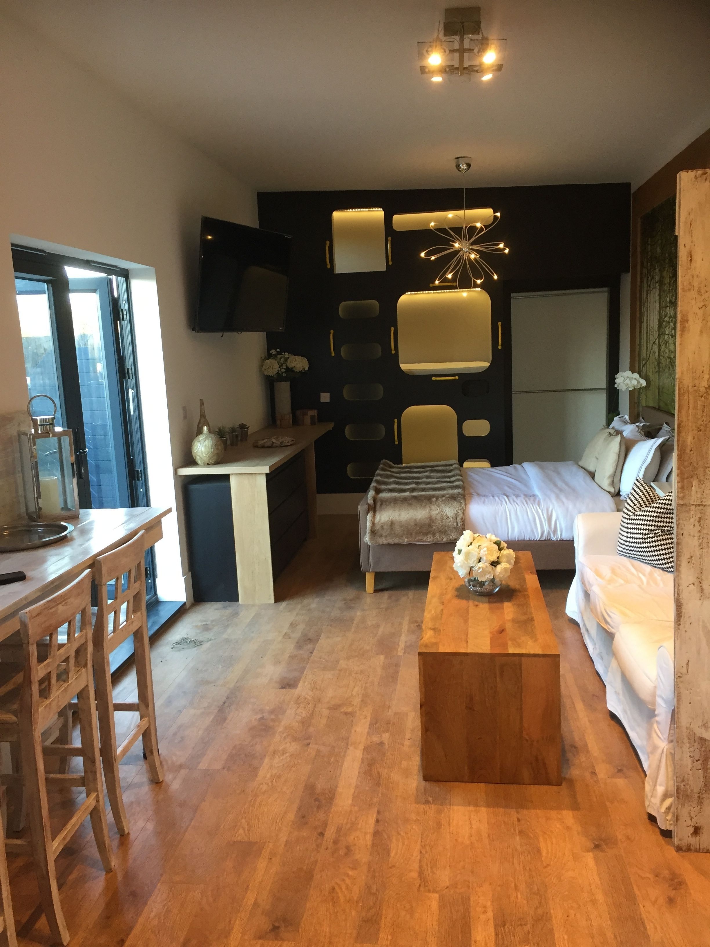 Un espacio habitable compacto con kitchenette, comedor y sofá.