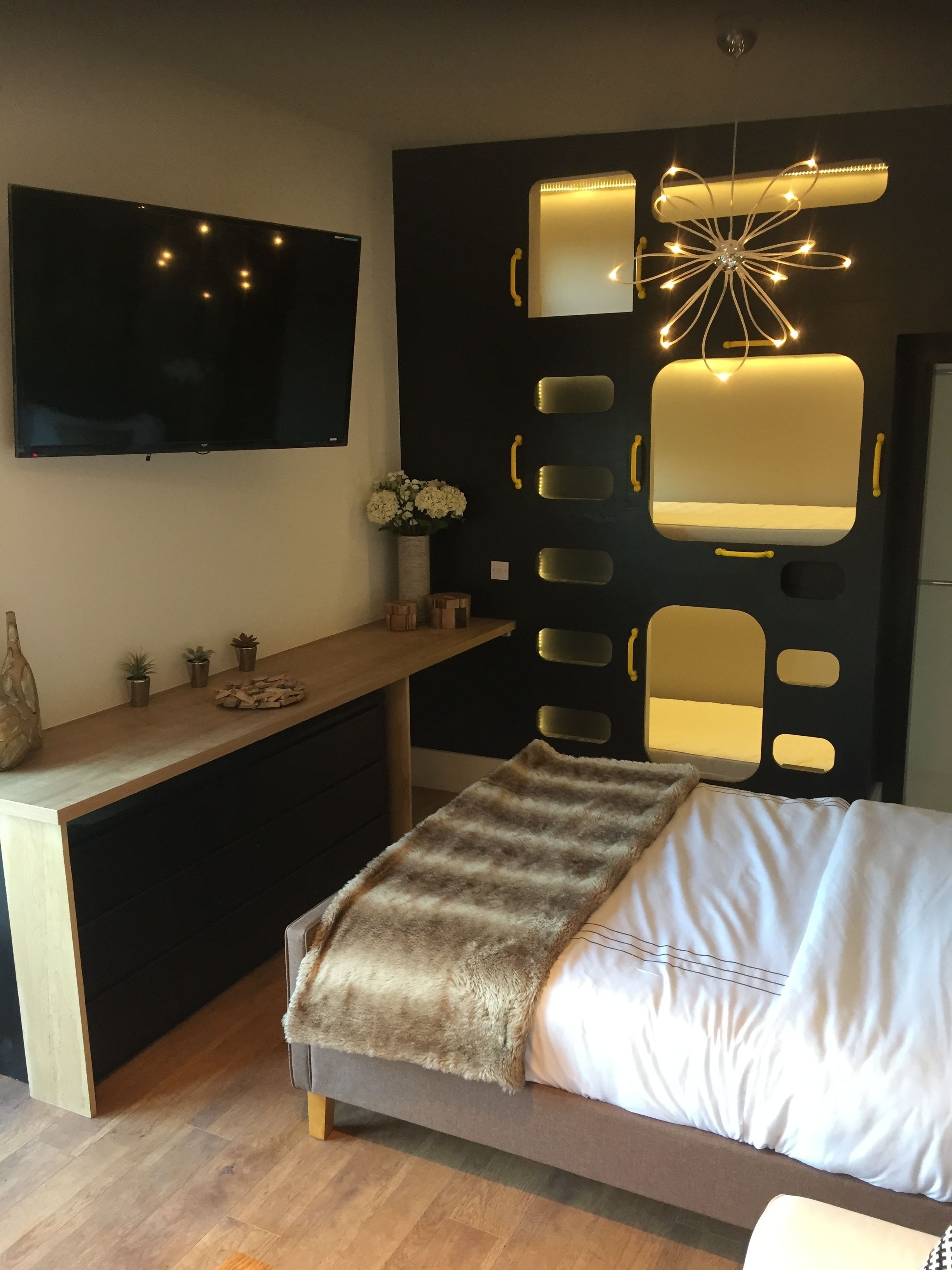 Een moderne slaapkamer met een bed, een bureau en een televisie.