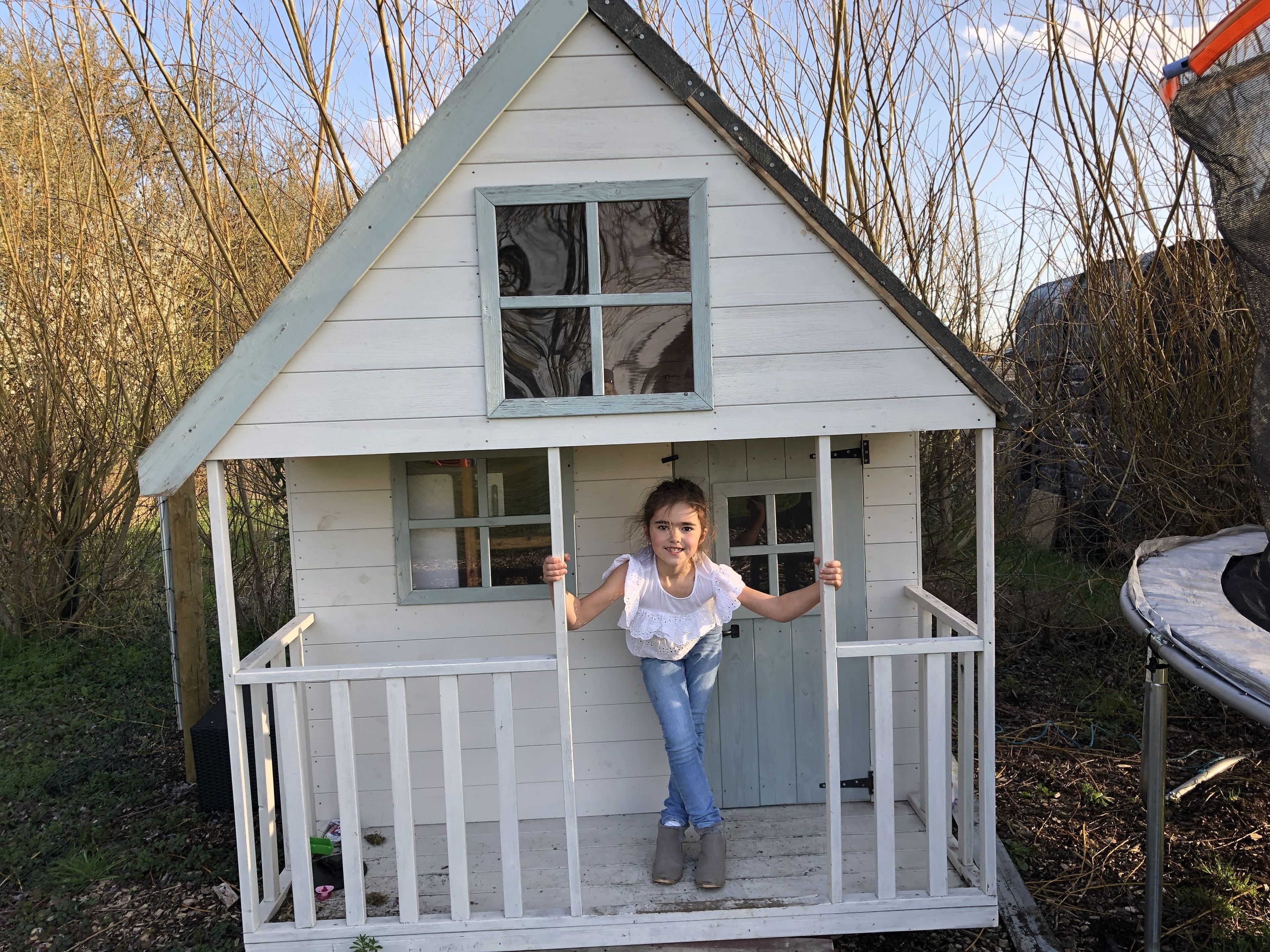 Ein kleines Holzhaus mit Veranda und Fenster.