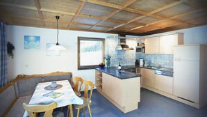 Una cocina compacta con armarios de madera, una mesa de comedor con sillas y una isla integrada.