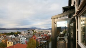 A balcony with a view of a lake and buildings. - Breidablikk Gjestehus (Narvik)
