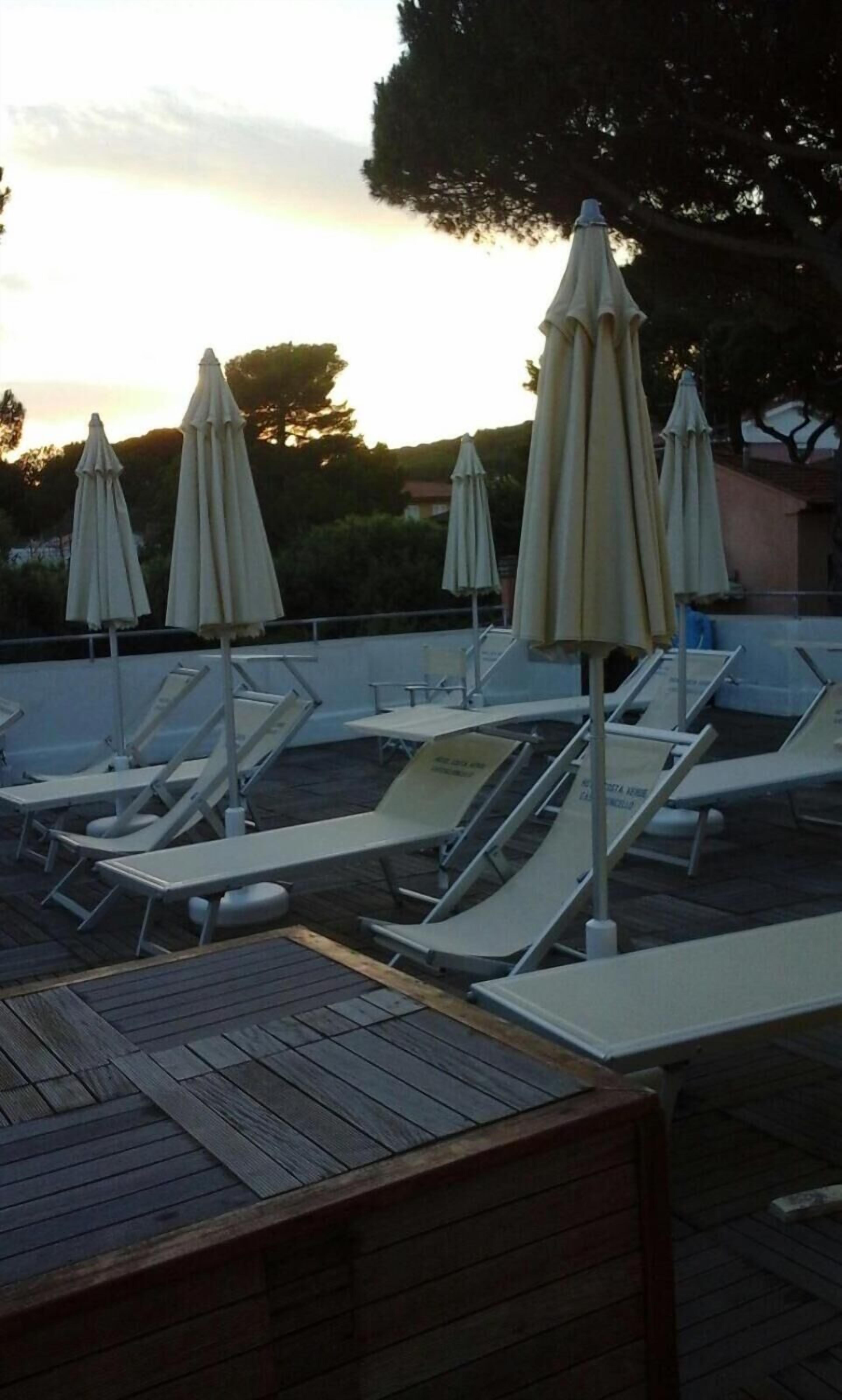 Una piscina al aire libre de temporada, sombrillas
