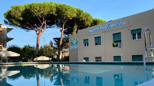 A hotel named Costa Verde with a swimming pool, trees, and a clear sky. - Hotel Costa Verde (Rosignano Marittimo)