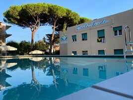 Una piscina al aire libre de temporada, sombrillas