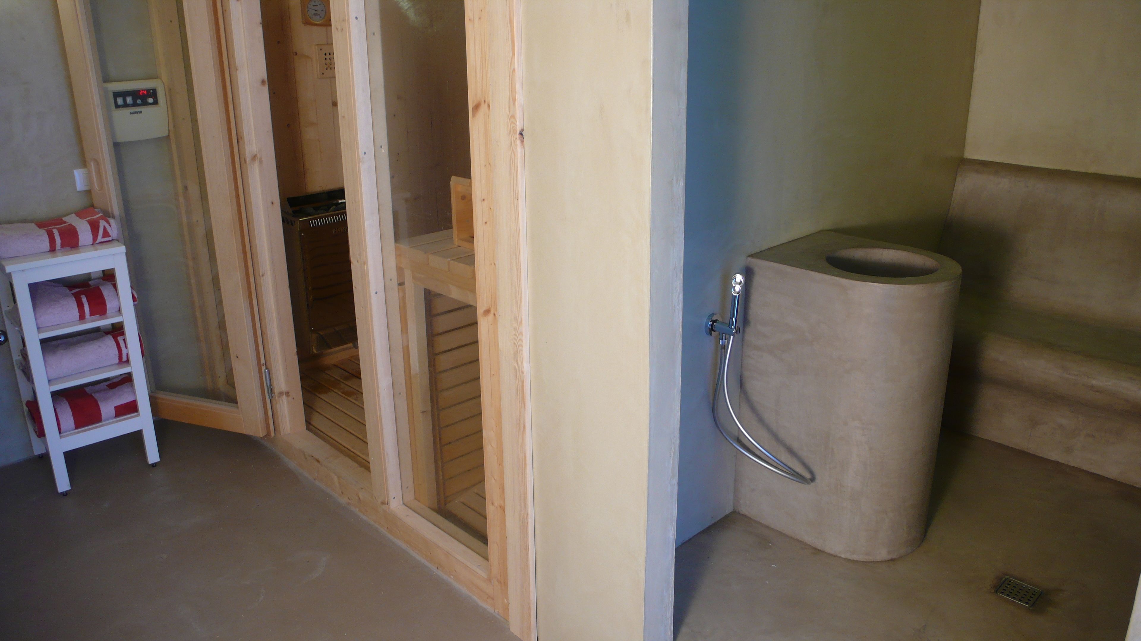 A bathroom with a wooden door, a towel rack, and a toilet.