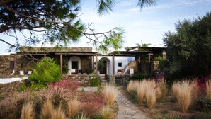 A stone pathway leading to a rustic building with a covered porch and a stone wall. - Zubebi Resort (Pantelleria)