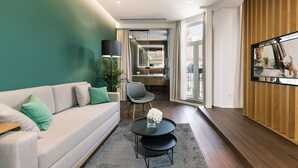 Ein modernes Wohnzimmer mit einer Couch, einem Couchtisch und einem an der Wand befestigten Fernseher.