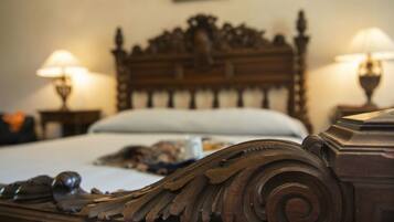 A wooden bed with intricate carvings, two bedside lamps, and a white pillow.