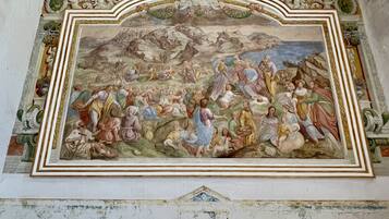 A fresco mural with classical figures and architectural elements.
