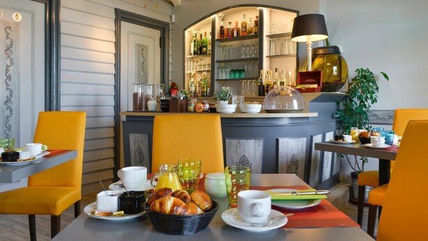Un ambiente de desayuno con una barra, alimentos para el desayuno y una disposición de asientos.