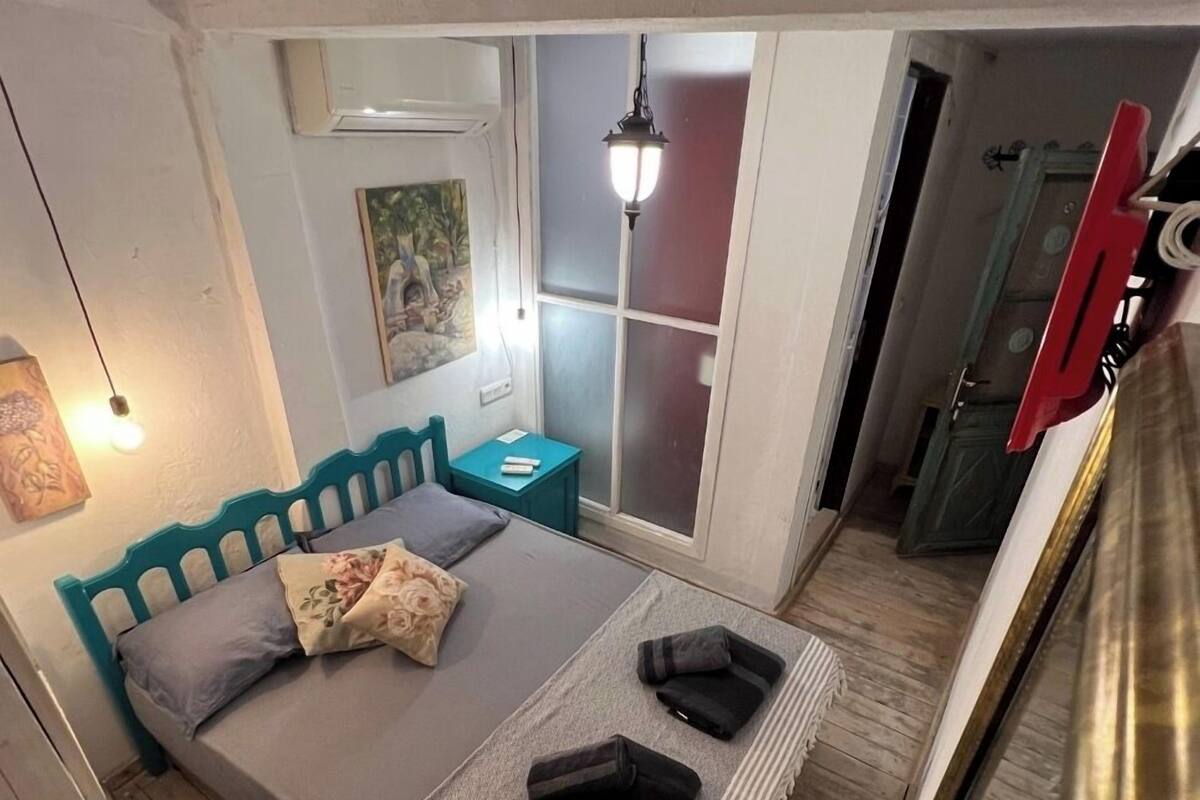 Une chambre à coucher avec un lit, une table de chevet, une lampe et un tableau au mur.