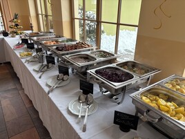 Una mesa de buffet con diferentes platos y utensilios.
