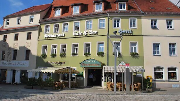 A building with a cafe and bar on the ground floor, a hotel on the second floor, and a restaurant named "Modehaus Jäger" on the left. - Hotel Evabrunnen (Bischofswerda)