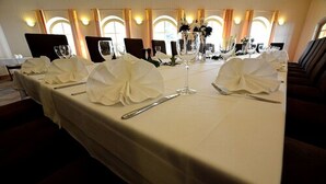 A long dining table with white tablecloths and folded napkins, set for a formal meal. - Hotel Evabrunnen (Bischofswerda)