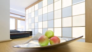 A room with a wooden floor, a table with a white plate holding three apples, and a large window with a view of the outside. - Hotel Tesla - Smart Stay (Belgrade)