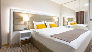 A hotel room with a large bed, bedside tables, a mirror, and a headboard with integrated lighting. - Hotel Tesla - Smart Stay (Belgrade)