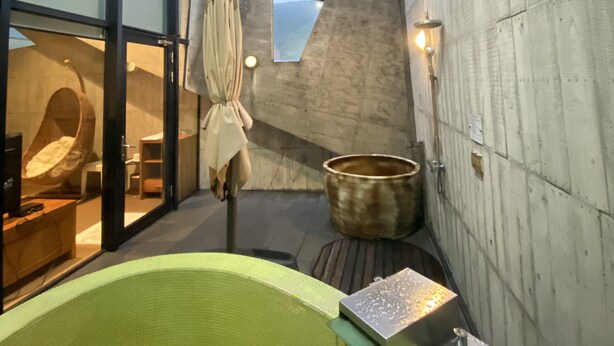 A modern bathroom with a large bathtub, a hanging chair, and a stone basin. - Smoking Rock Resort (Jiaoxi)