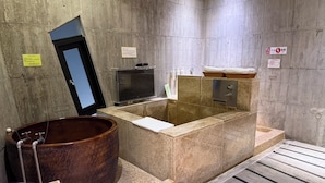 A modern bathroom with a large soaking tub, a small television, and a towel rack. - Smoking Rock Resort (Jiaoxi)