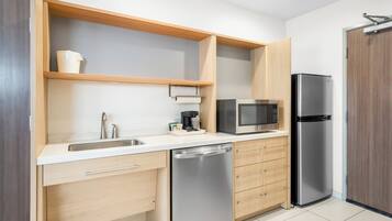 A modern kitchen with a stainless steel dishwasher, a microwave, and a refrigerator.