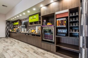 Un bar à petit-déjeuner moderne proposant une variété de plats et de boissons, notamment un espace dédié aux yaourts et au lait, ainsi qu’une machine à café.