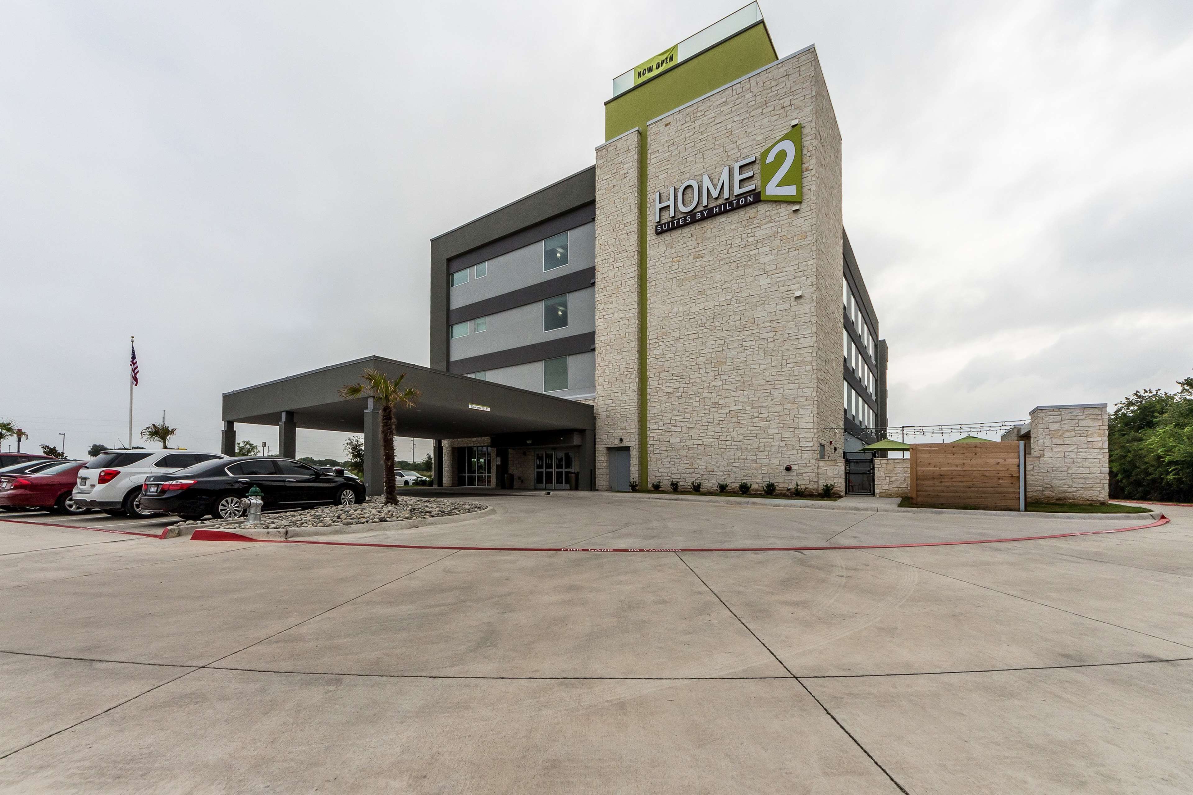Hotel modern amb façana de pedra i un rètol que diu "HOME 2 Suites by Hilton".
