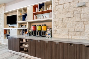 Cocina moderna con electrodomésticos integrados, un televisor de pantalla plana y varios armarios de almacenamiento.
