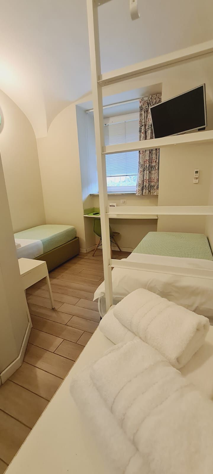 Une petite pièce avec des lits superposés, un bureau et une chaise.
