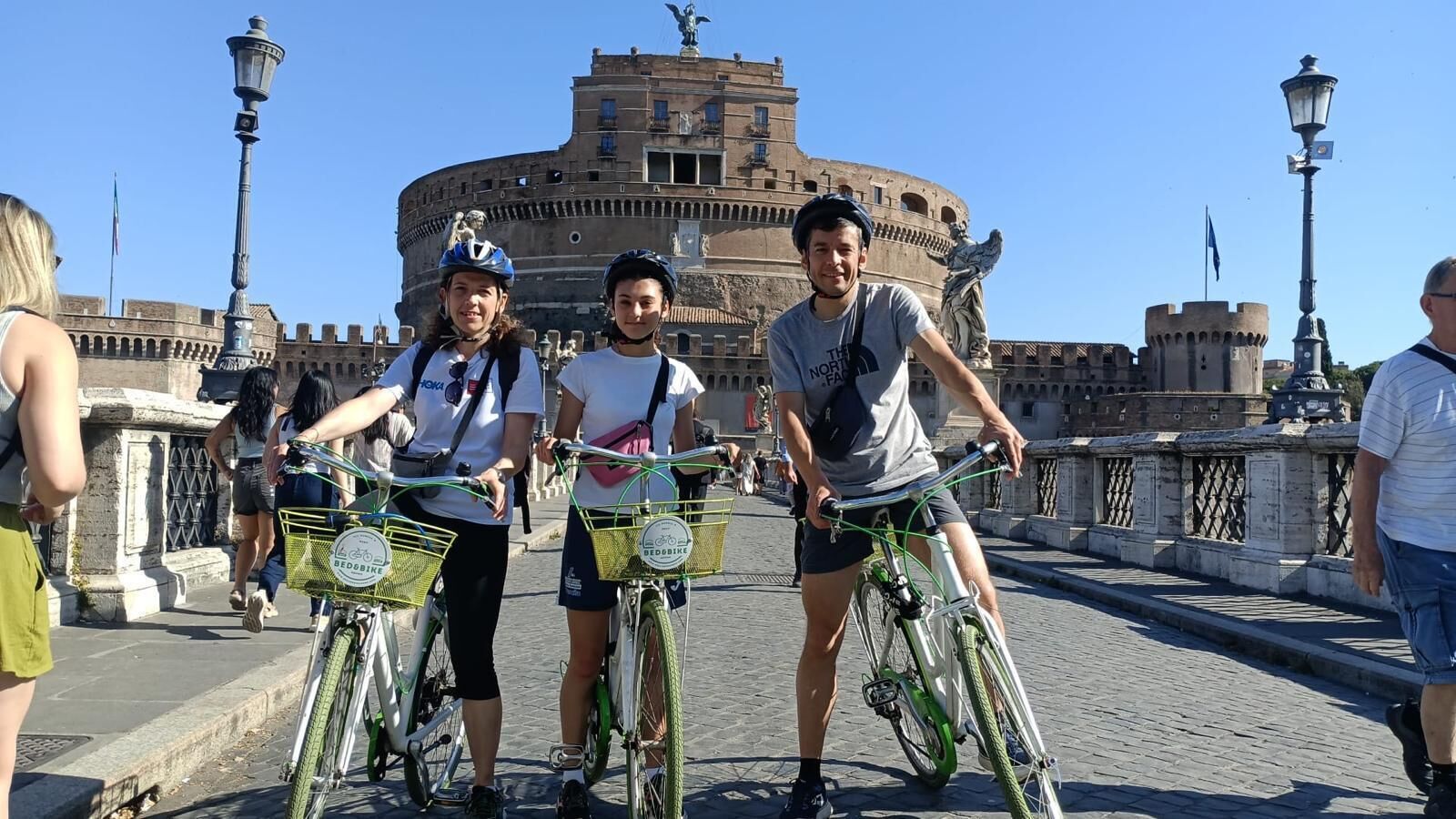 A group of people on bicycles with a historic building in the background.