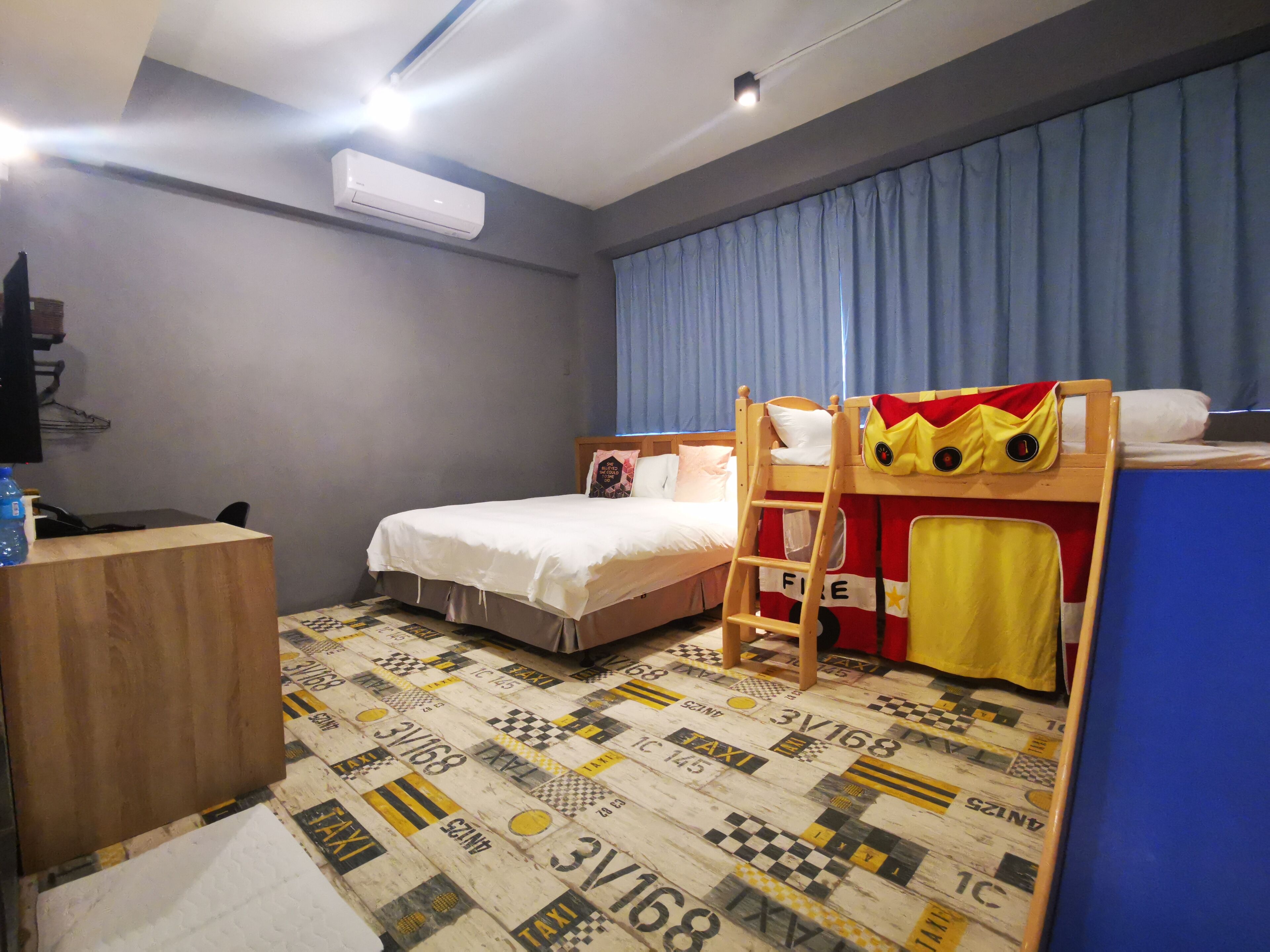 Ein Hotelzimmer mit Etagenbett, Schreibtisch und einem gemusterten Boden.