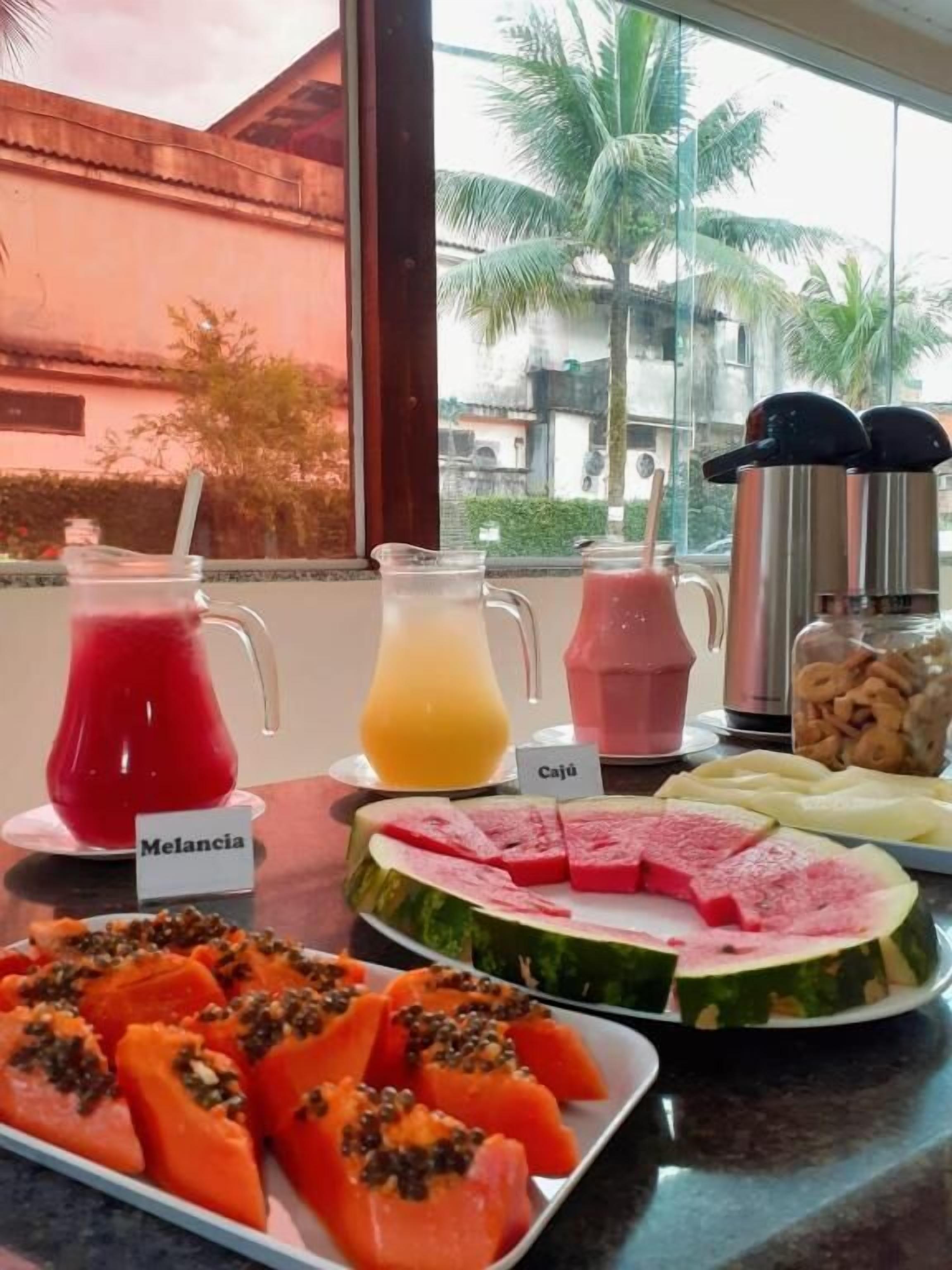 Un buffet de petit-déjeuner proposant une variété de fruits et des boissons clairement identifiées.