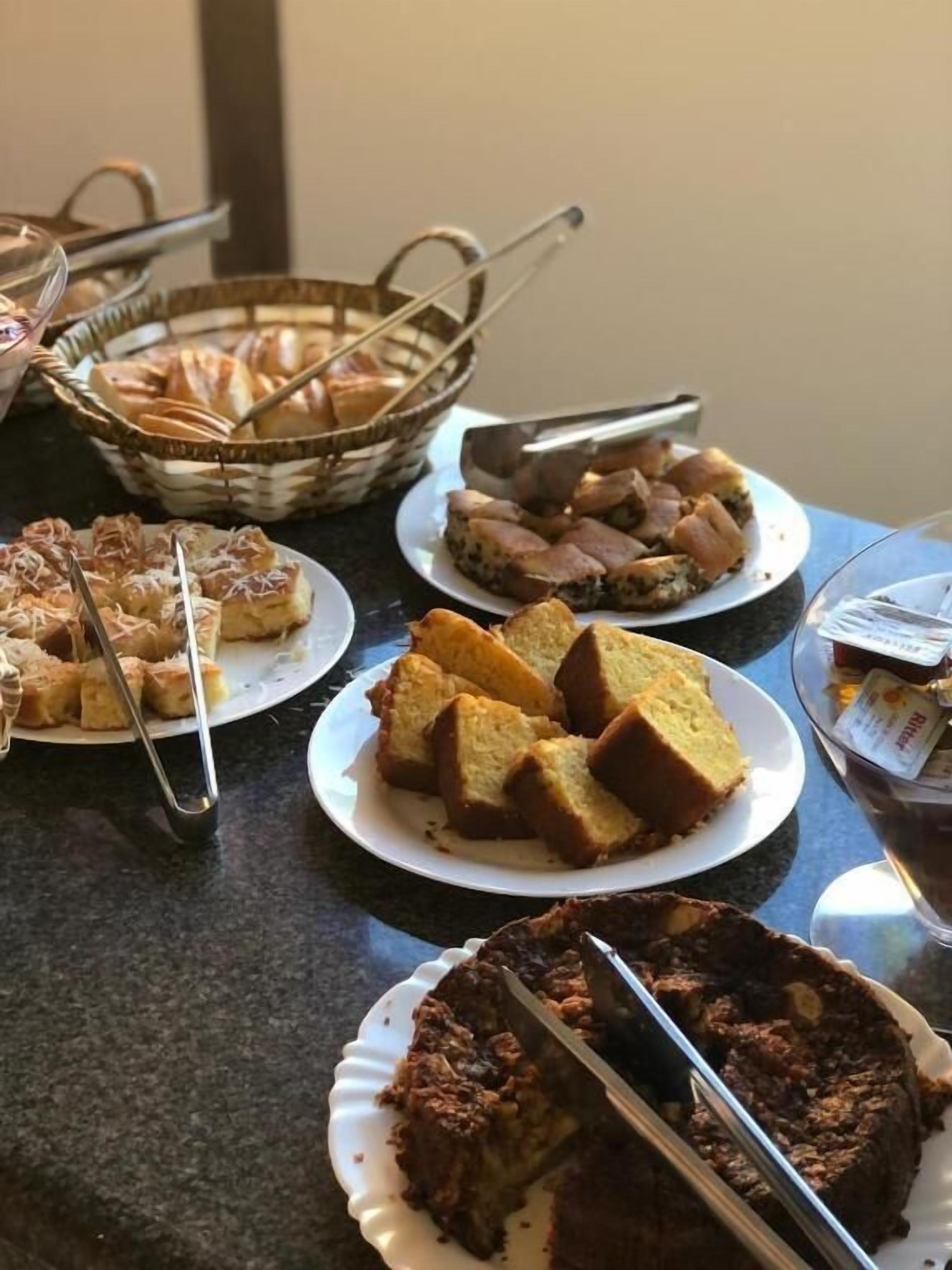 Una mesa de buffet con diferentes productos de pastelería y un pastel.