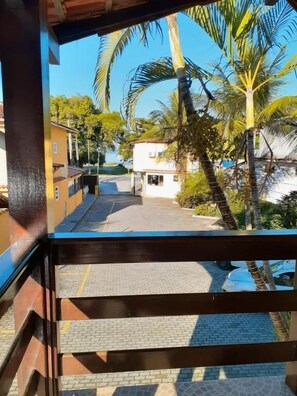 A view from a balcony overlooking a street with palm trees and buildings. - Pousada do Cardoso (Angra dos Reis)
