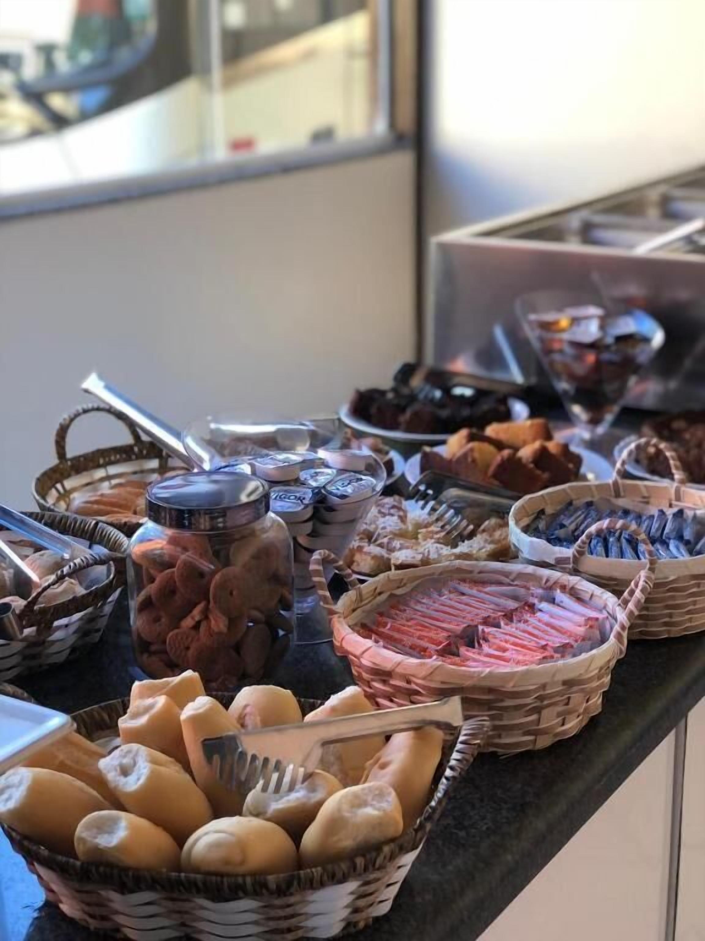 A buffet with various food items including bread, pastries, and meat.