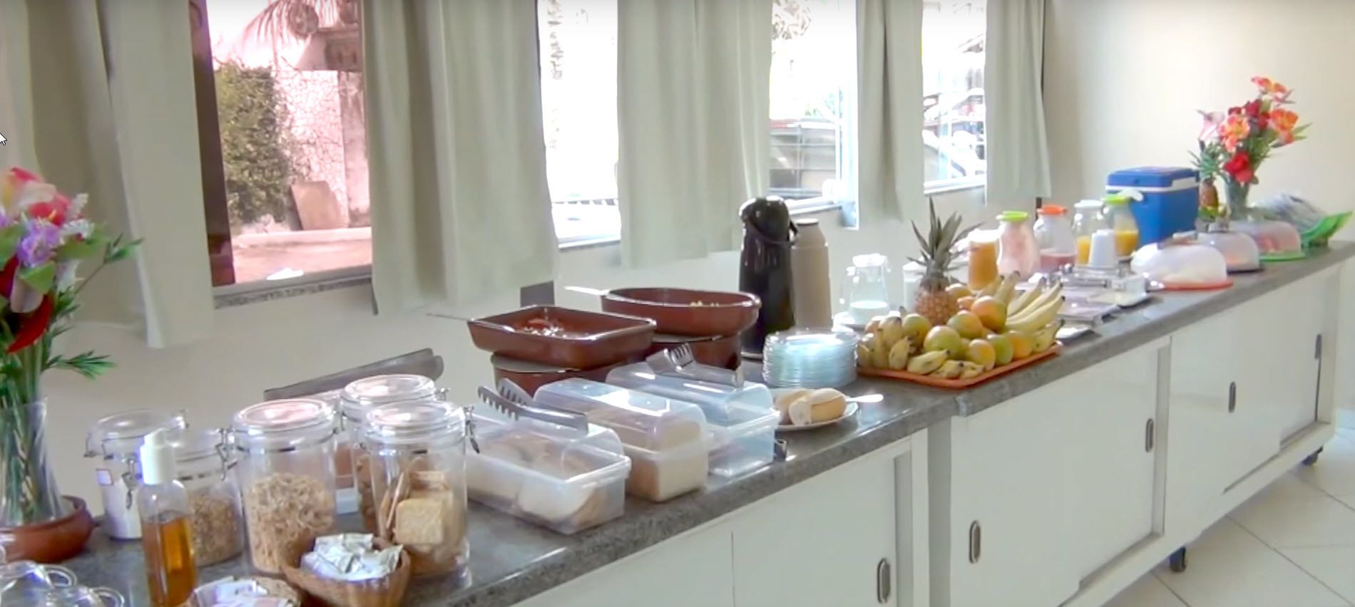 Un plan de travail de cuisine avec divers aliments et récipients, notamment des fruits, du pain et des condiments.