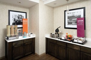 Una kitchenette con cafetera, tostadora y varios recipientes para alimentos.