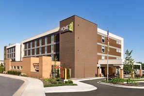 Home 2 hotel features a striking facade with a covered entrance and landscaped garden.