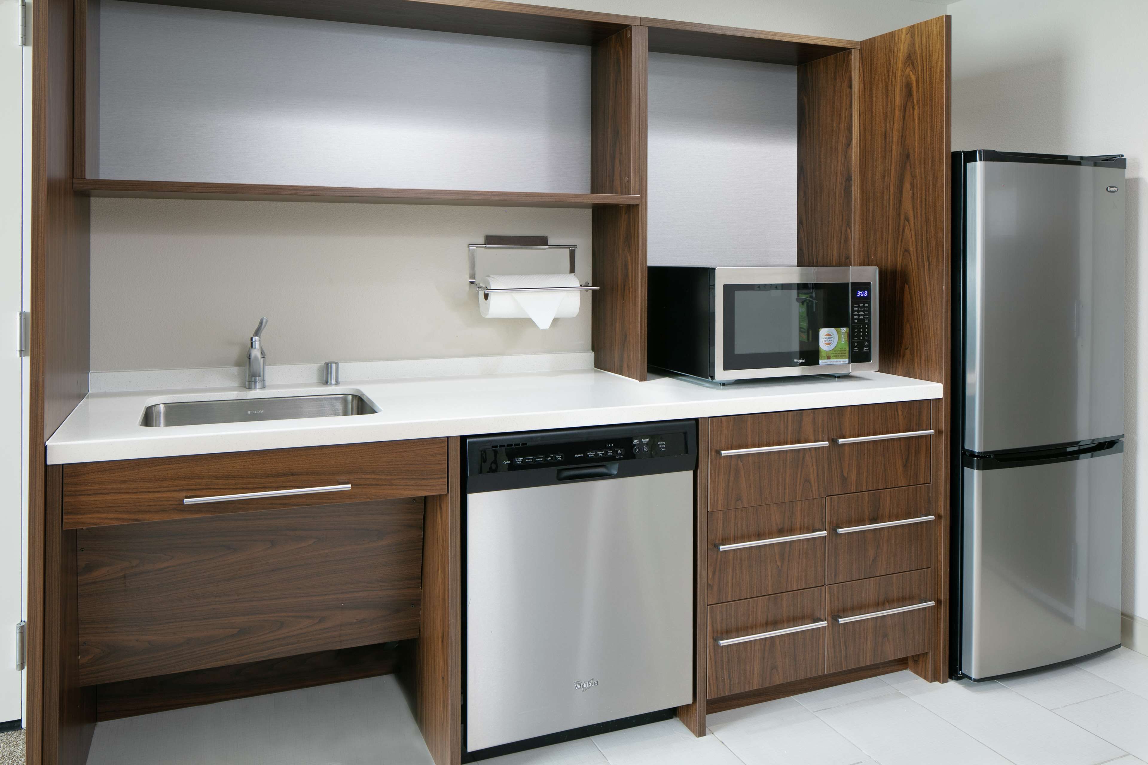 A modern kitchen with a stainless steel dishwasher, a microwave, and a refrigerator.