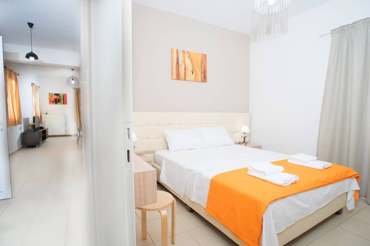 Une chambre d’hôtel moderne, dotée d’un grand lit, d’un bureau et d’une chaise.