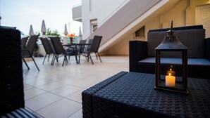 Un espace extérieur aménagé avec des meubles en osier, une table et des chaises.