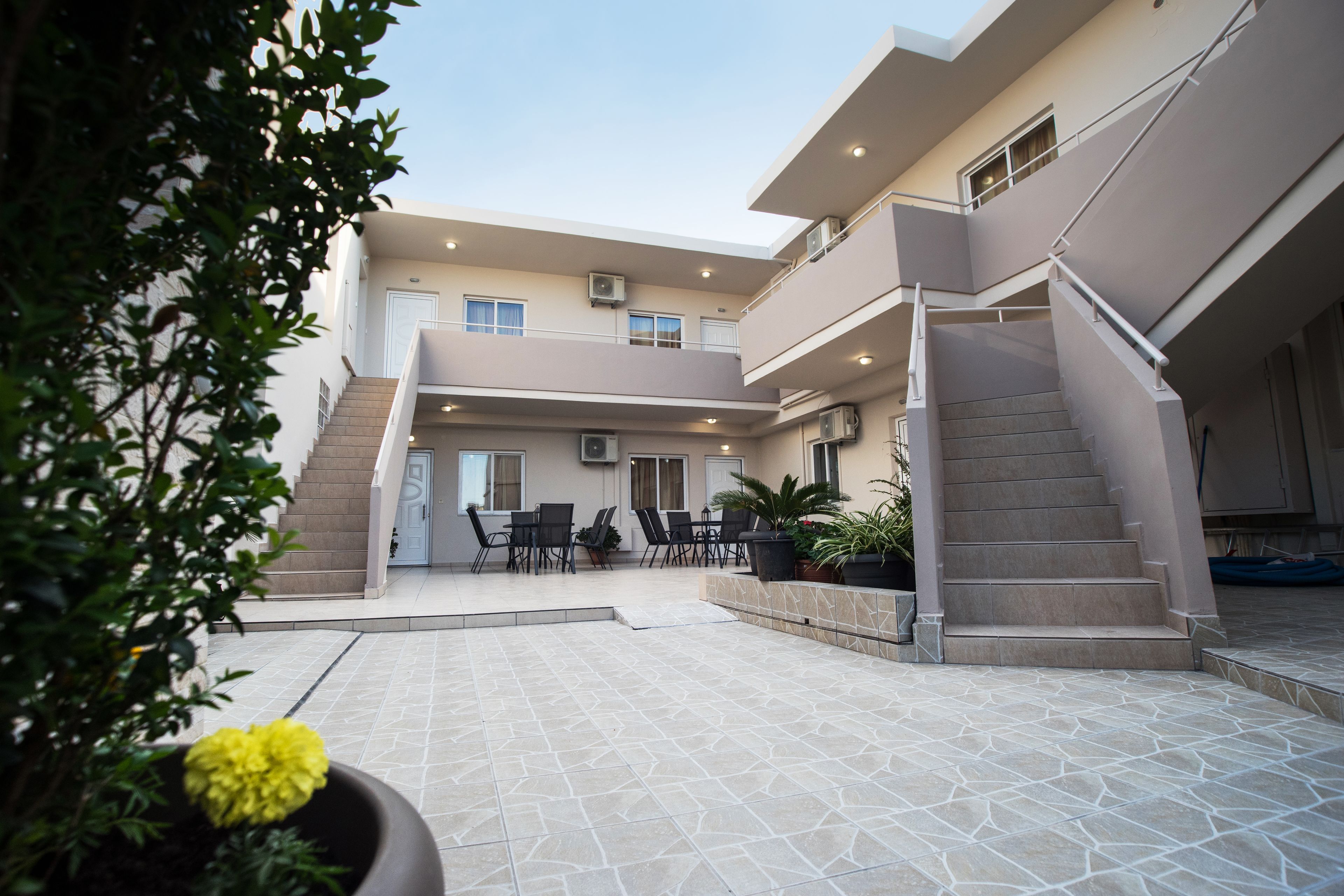 A modern building with a courtyard, outdoor seating area, and a staircase.