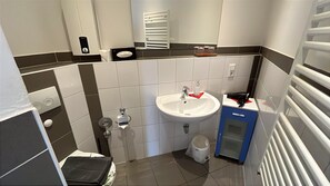 Een kleine badkamer met een wastafel, toilet en handdoekrek.