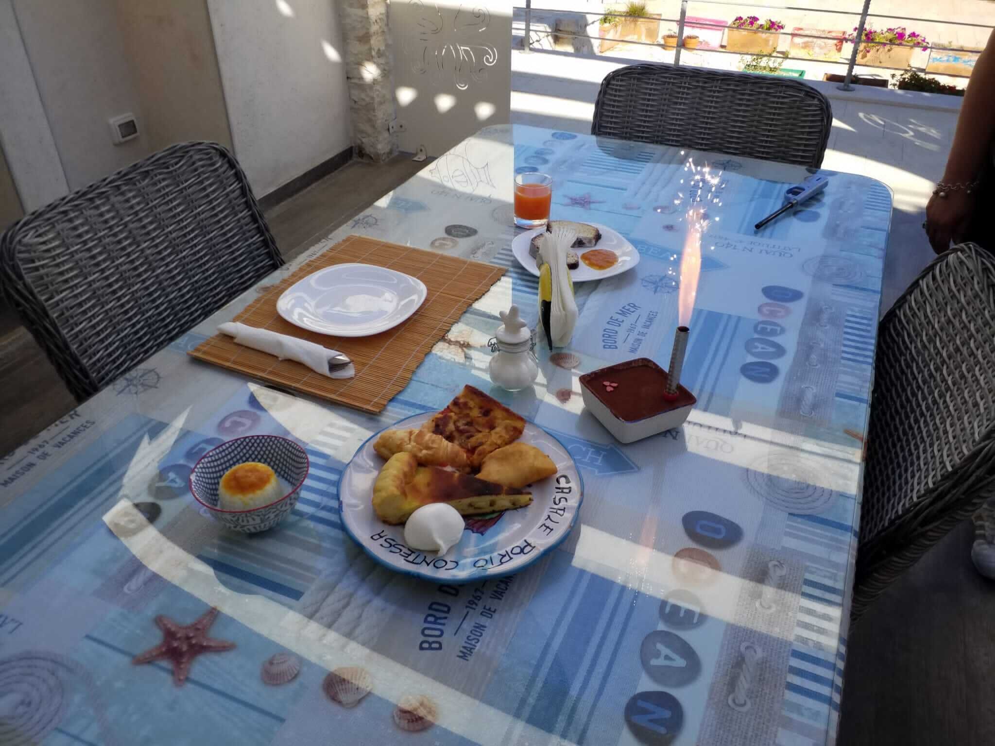Ein Frühstückstisch mit Speisen, einer Kerze und einer Wasserflasche.