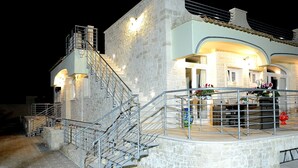 A stone building with a staircase leading to a balcony.