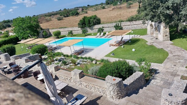 Ein Poolbereich mit Steinarchitektur und Sitzmöglichkeiten im Freien.