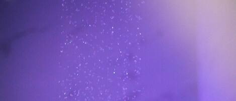 A person submerged in water with a purple light in the background.