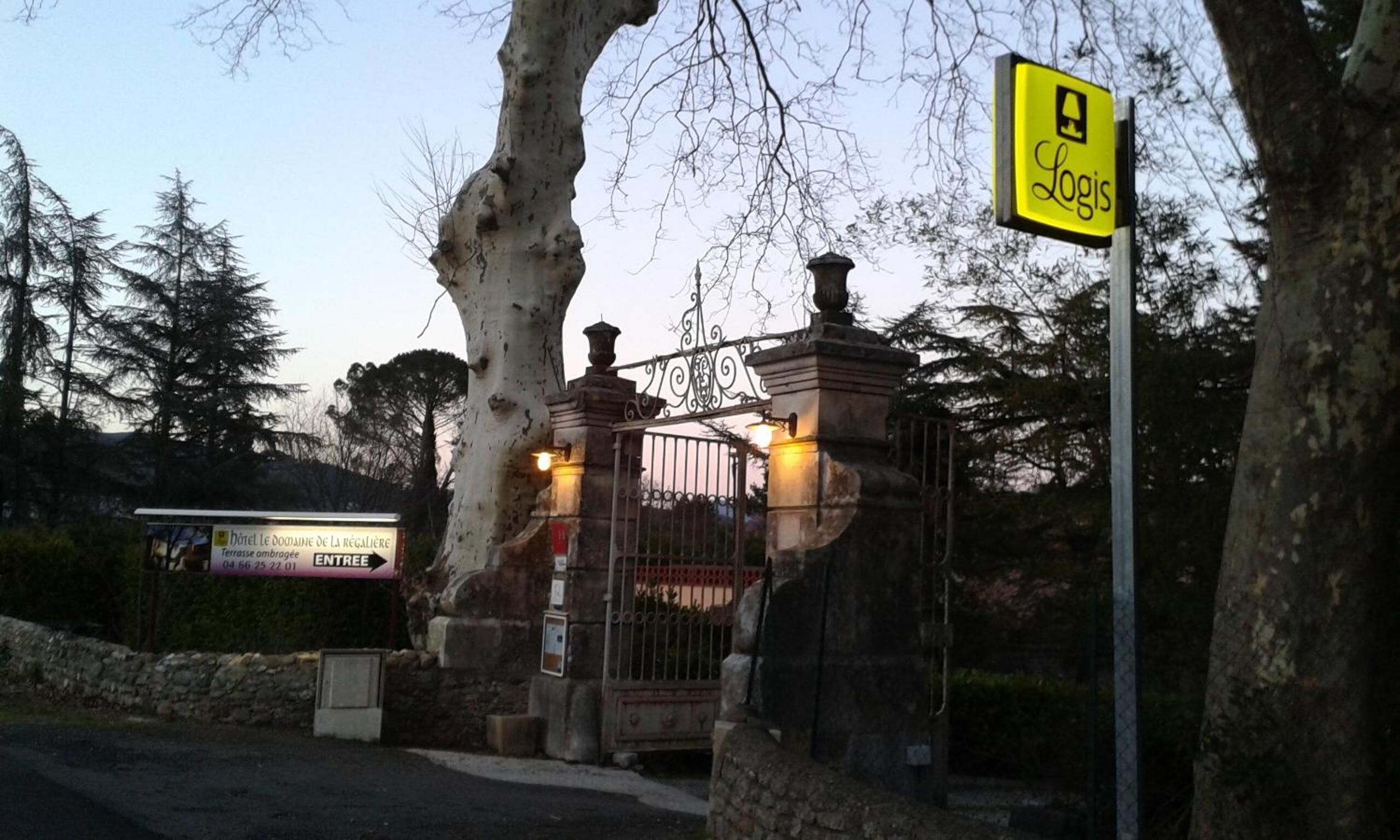 Una entrada con puerta y señalización para 'Logis' y letrero de hotel 'Hôtel Le Domaine de La Régalérie'.