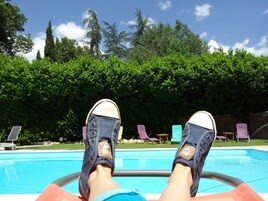 Una piscina al aire libre de temporada, sombrillas