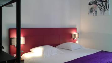 A single-bed room with a red headboard, white bedding, and two wall-mounted lamps.