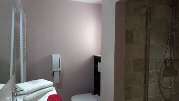 Ein Badezimmer mit Dusche, Toilette, Waschbecken und Handtuchhalter.